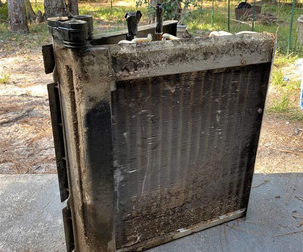 Dirty AC unit covered in debris and dust (before cleaning)